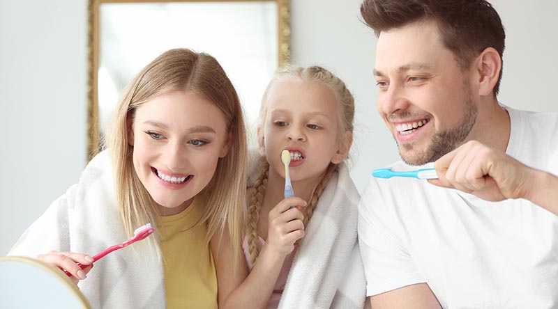 family cleaning teeth at home